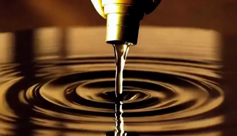 Golden ink blooming through dark water in slow motion